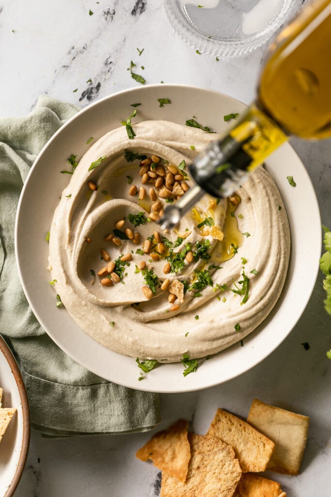 Best 5-Minute Blender Hummus - drizzling olive oil over bowl of hummus