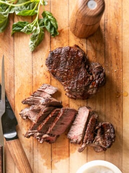 How To Grill Filet Mignon - grilled steaks on cutting board sliced with carving knife
