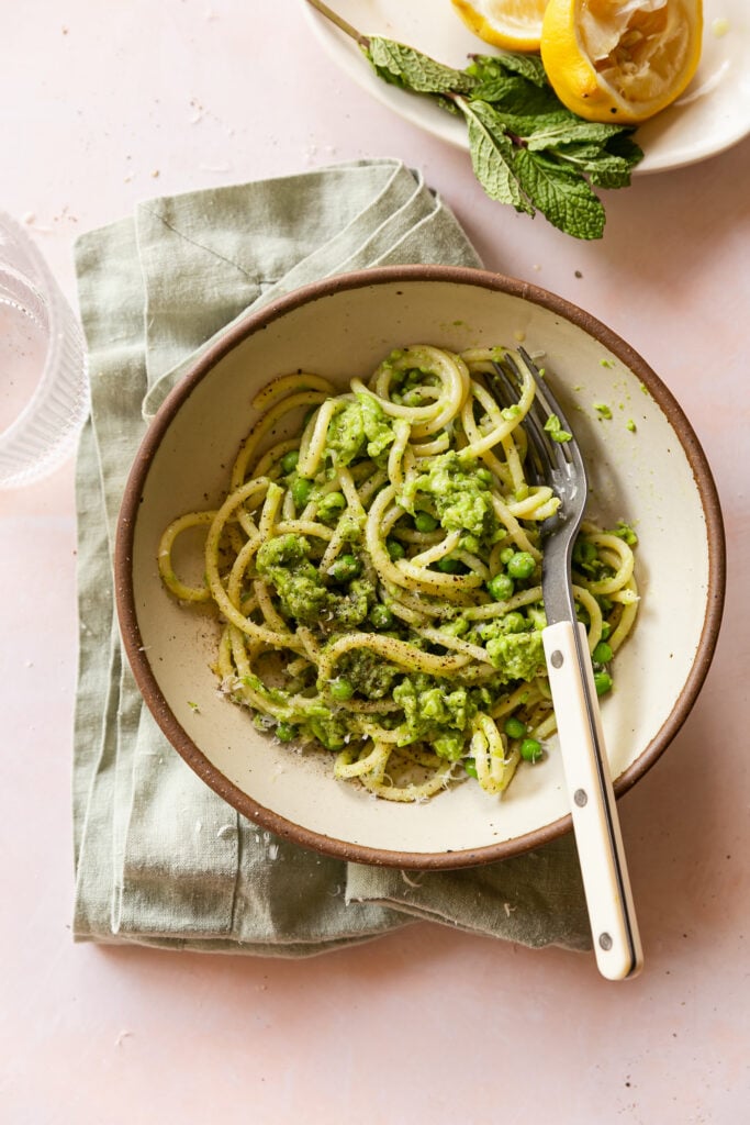 Pea Pesto - pesto with buccatini pasta in bowl with fork and napkin