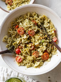 pasta salad in a bowl with serving utensils