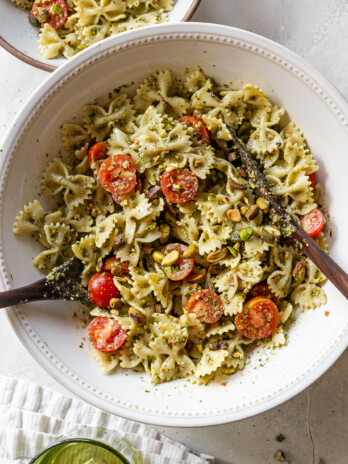 pasta salad in a bowl with serving utensils