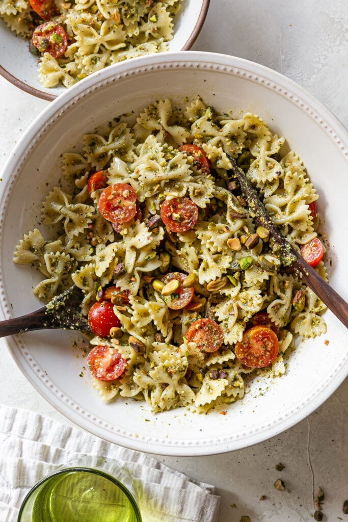 pasta salad in a bowl with serving utensils