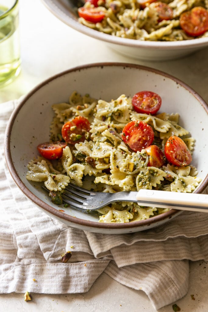 pasta salad in serving bowl with fork and napkin