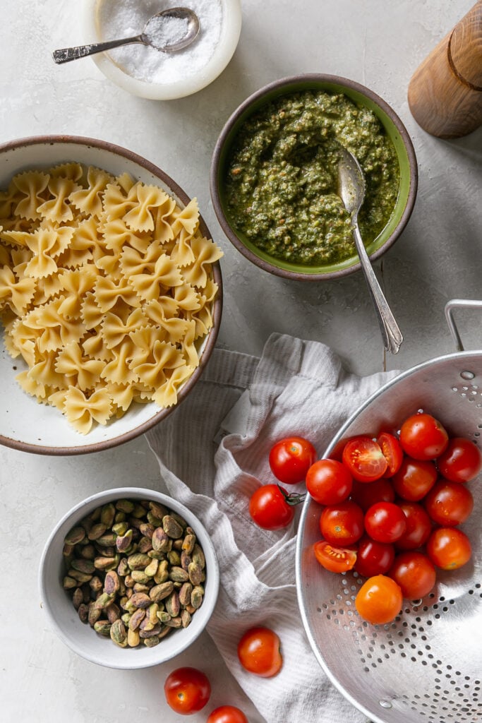 bowtie pasta, pistachios, cherry tomatoes and pesto in bowls