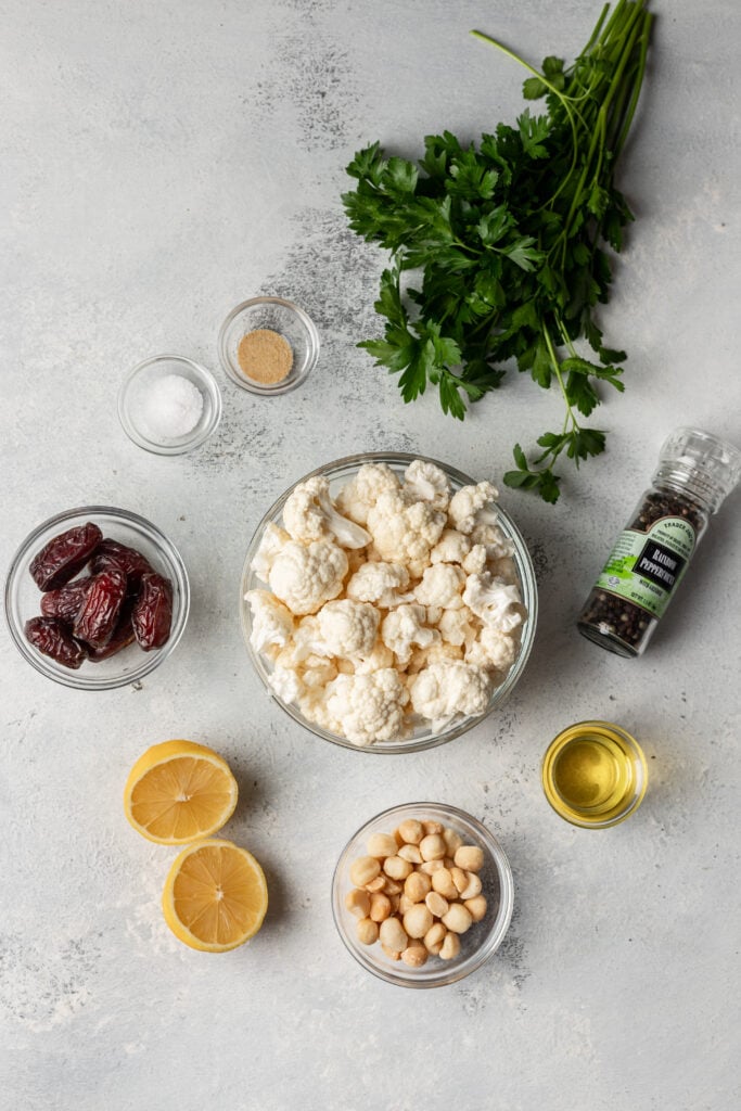 overhead shot of cauliflower, lemon, dates, parsley and spices