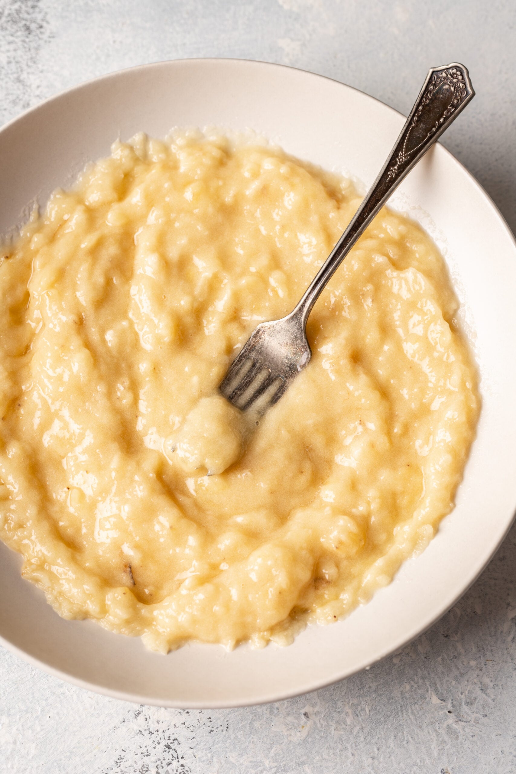 a bowl of mashed bananas with a fork