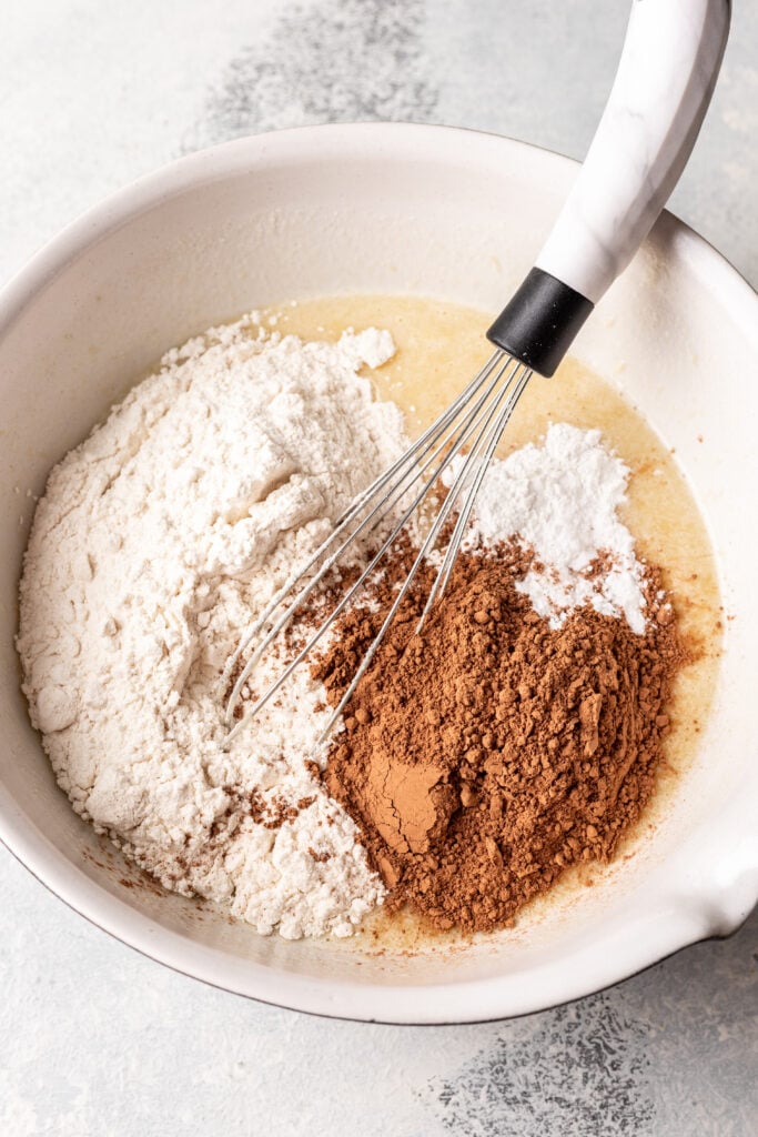 flour and cocoa powder in a bowl with a whisk