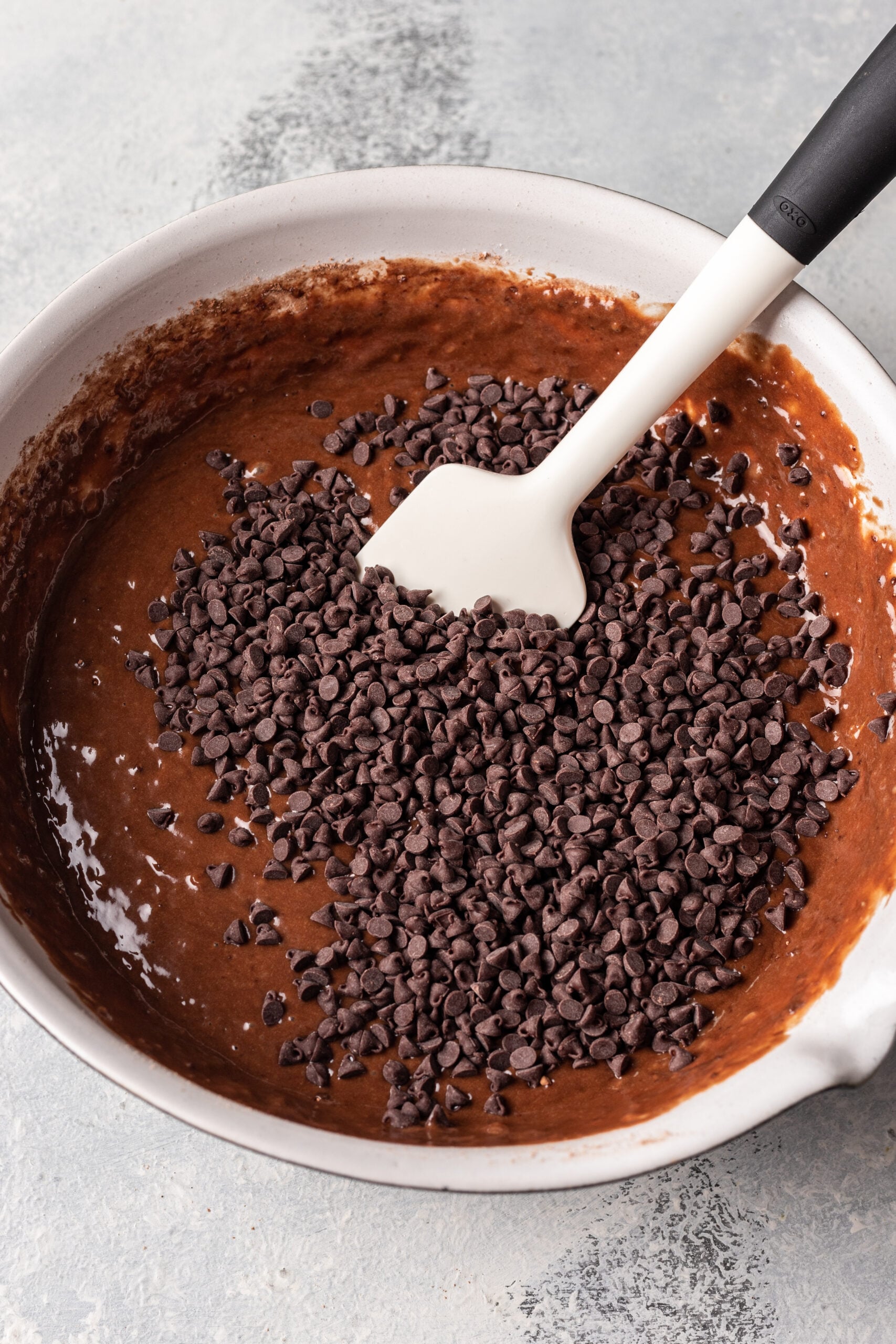 chocolate batter in a bowl with a whisk with chocolate chips