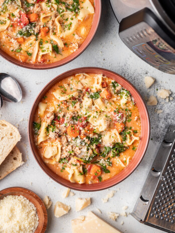 tortellini soup in a bowl with parmesan cheese