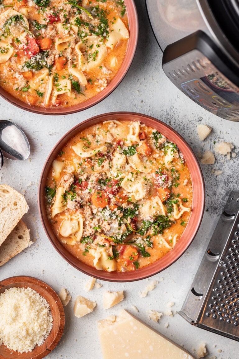 tortellini soup in a bowl with parmesan cheese