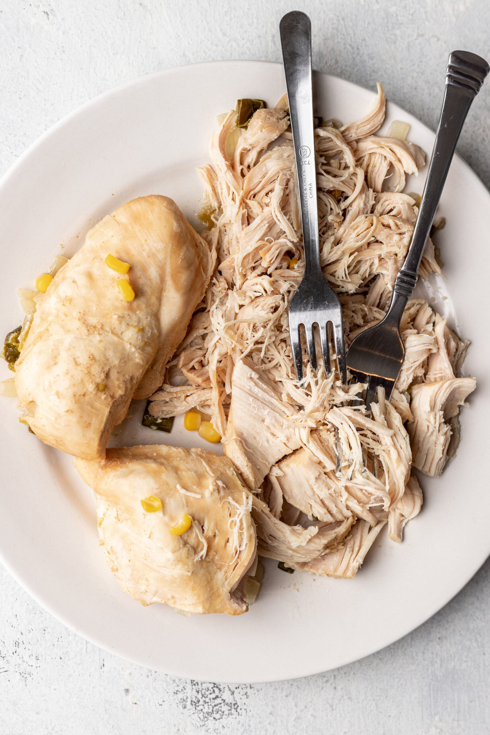 shredded chicken on a plate with 2 forks