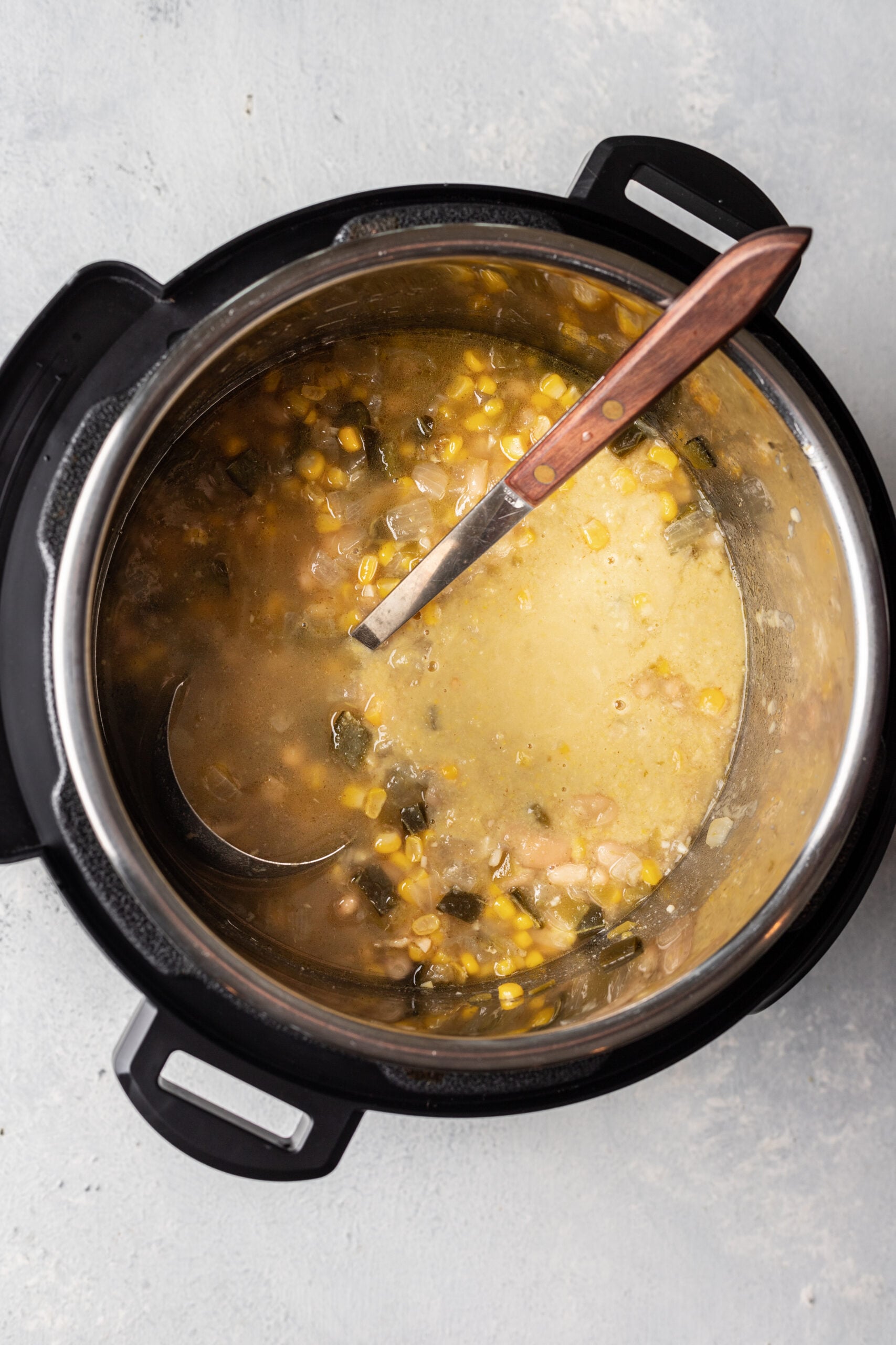 white chicken chili in an instant pot with a ladle