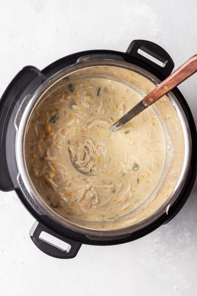 white chicken chili in an instant pot with a ladle