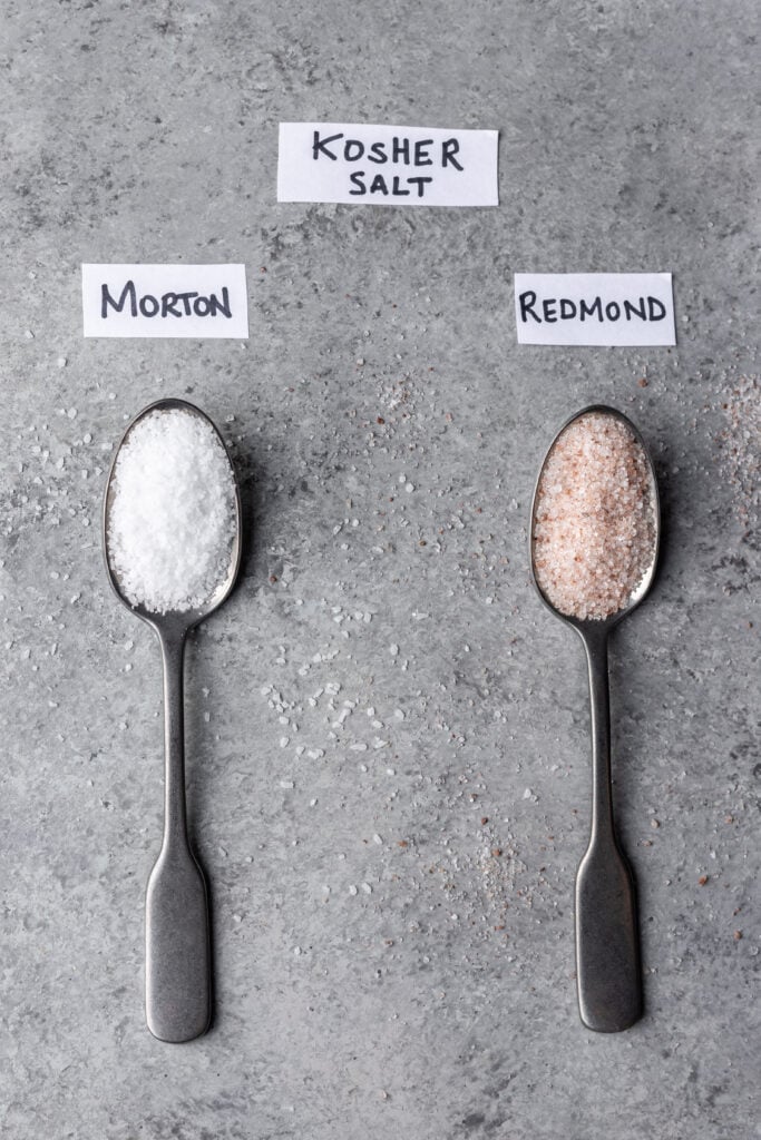two spoons on a board filled with kosher salt