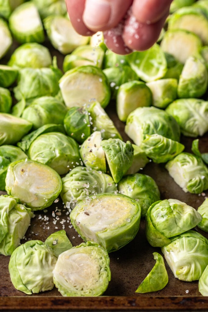 raw brussles sprouts on a sheet pan sprinkled with salt