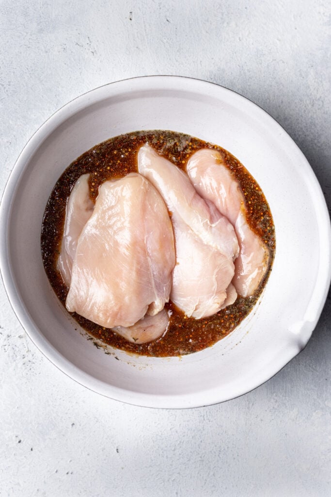 chicken marinating in a baking dish