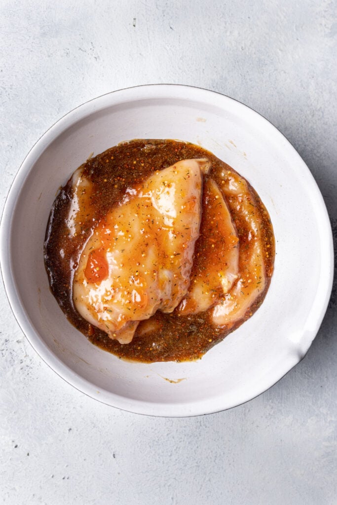 chicken marinating in a baking dish