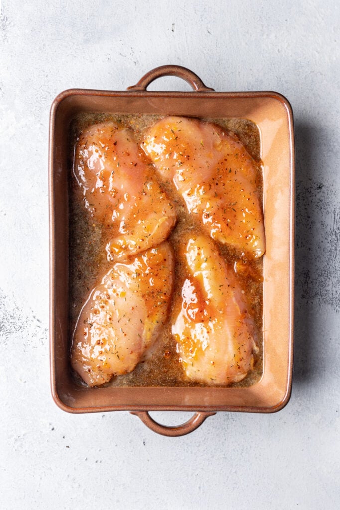 chicken marinating in a baking dish