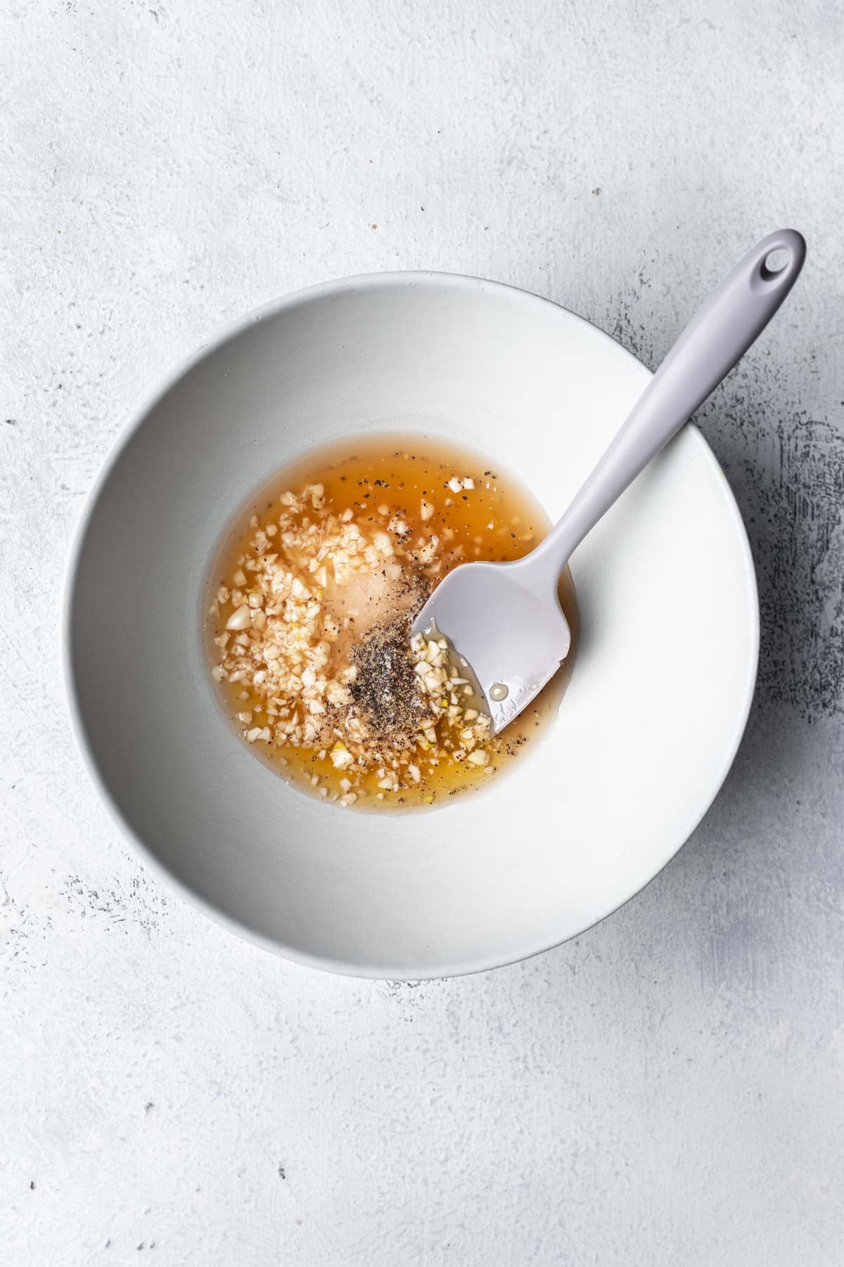 a bowl with sauce, garlic and spices