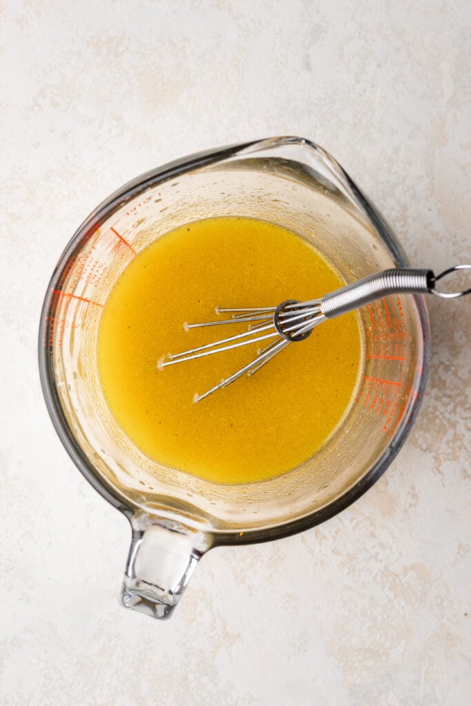 citrus dressing in a measuring cup with a whisk