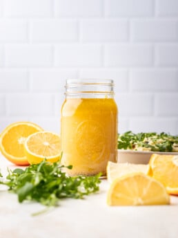 citrus dressing in a jar with lemons all around