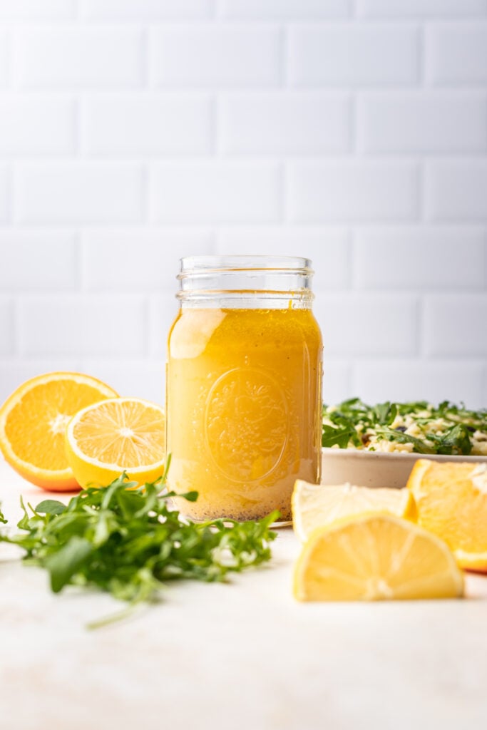 citrus dressing in a jar with lemons all around