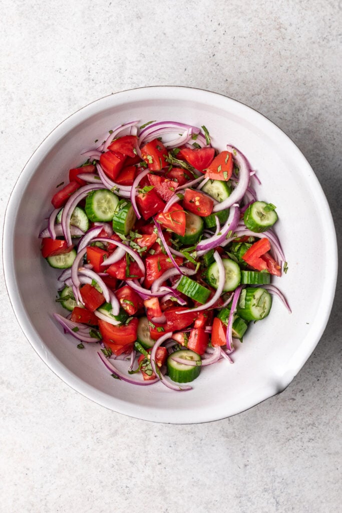 tomatoes, cucumber and red onion in a bowl