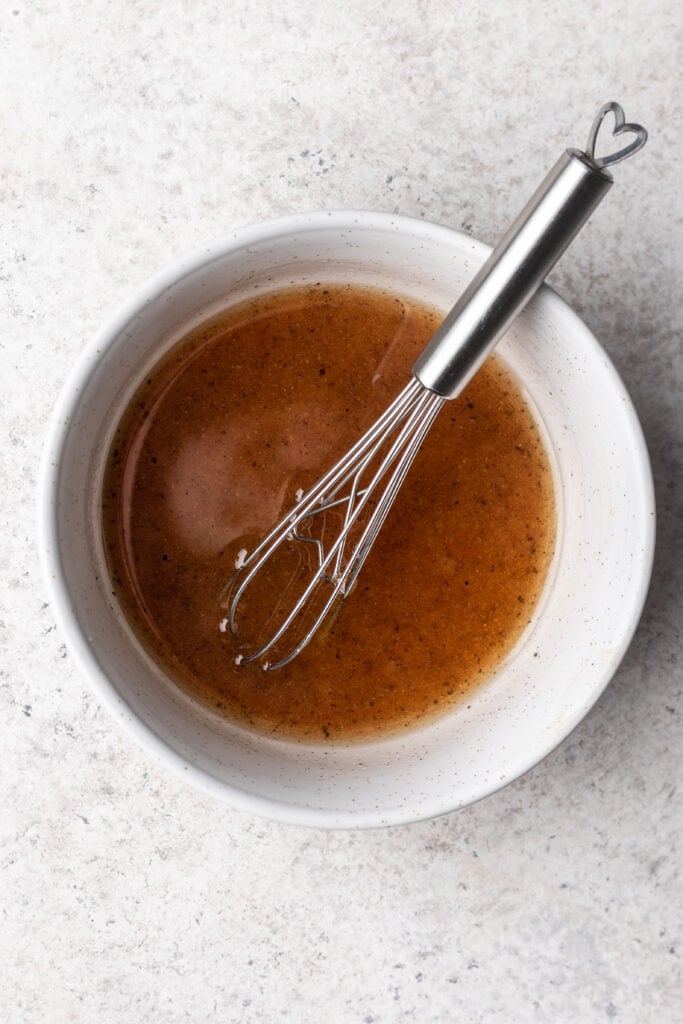 salad dressing in a bowl with a whisk