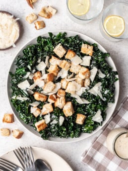 kale caesar salad in a bowl with croutons and cheese on top