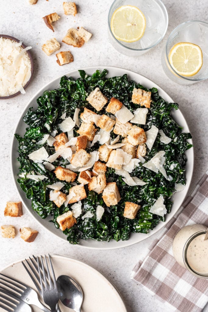 kale caesar salad in a bowl with croutons and cheese on top