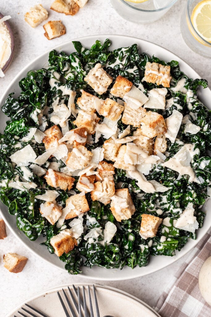 kale caesar salad in a bowl with croutons and cheese on top