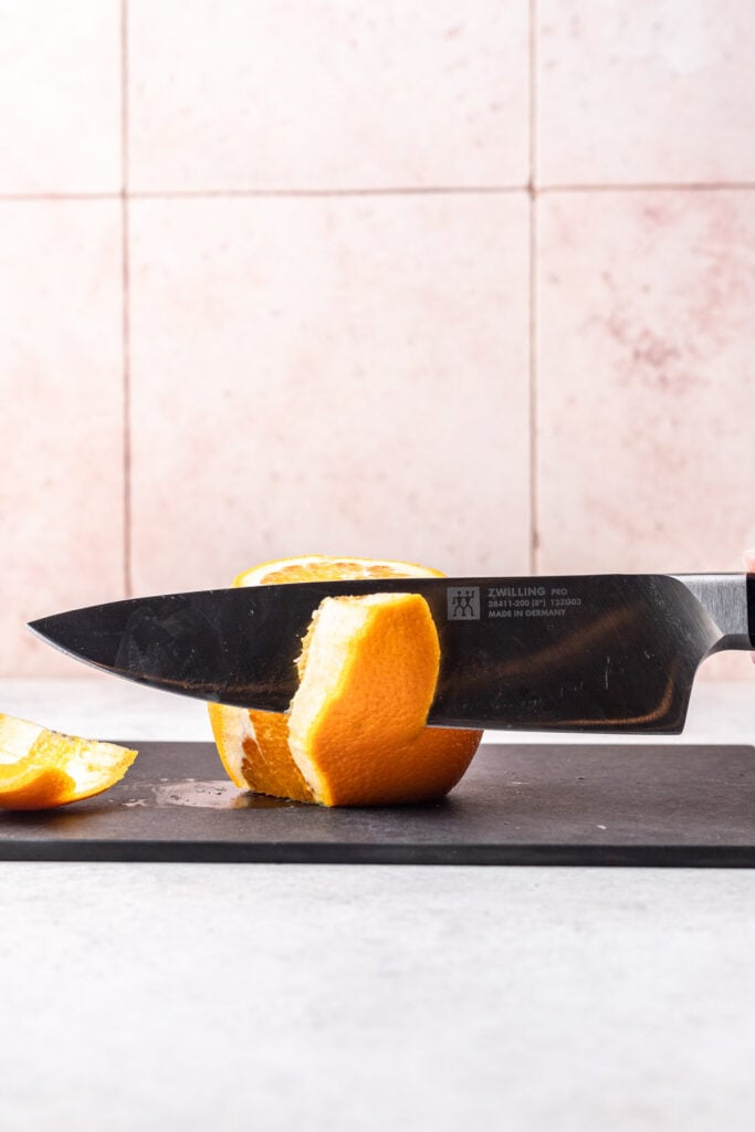 knife peeling an orange