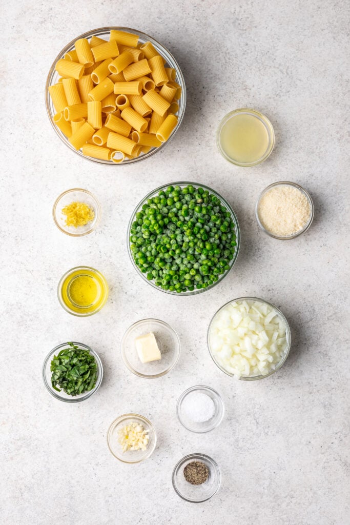 bowls of ingredients like peas, pasta, parmesan cheese and onion