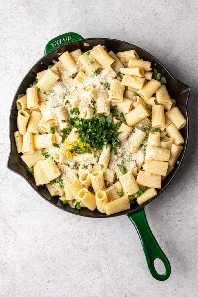 skillet with pasta, peas, cheese and herbs