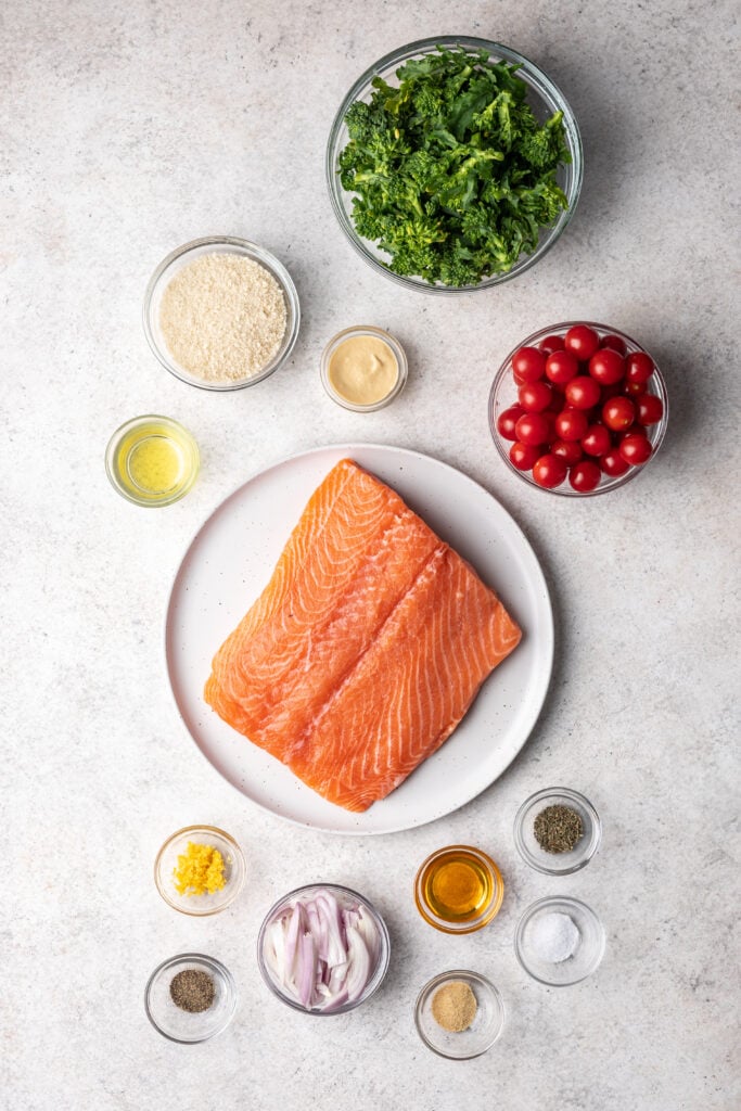 salmon filet on a plate with other ingredients in bowls surrounding
