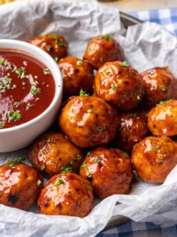 bbq meatballs on a plate with extra bbq sauce on the side