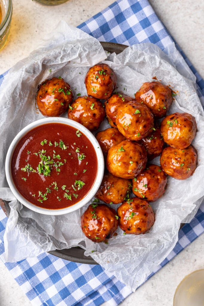 bbq meatballs on a plate with extra bbq sauce on the side