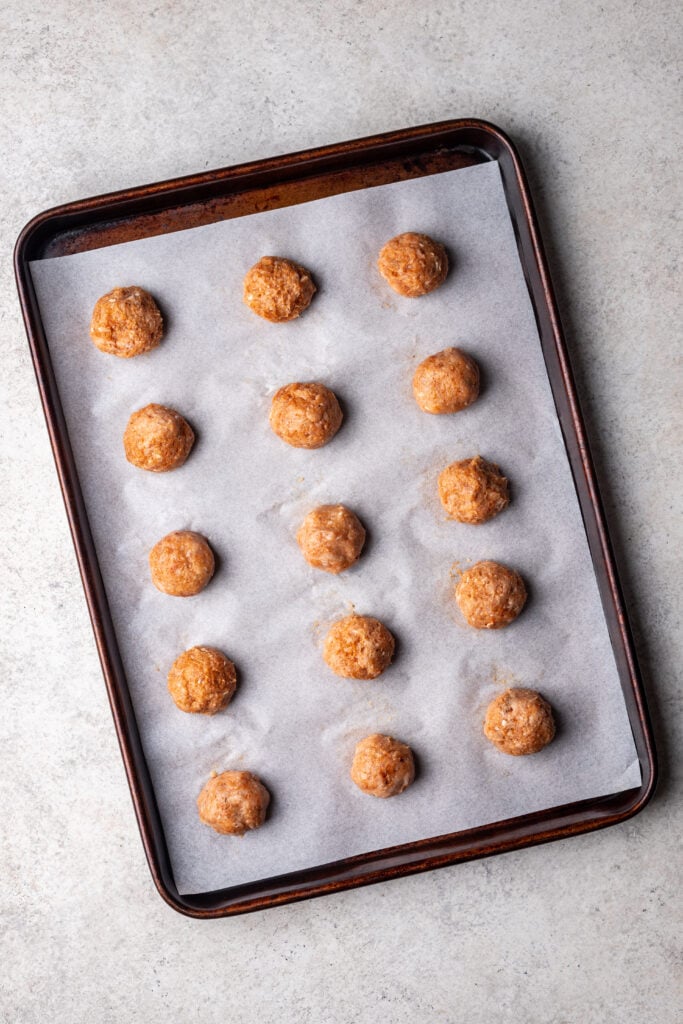 chicken meatballs on a sheet pan with parchment paper