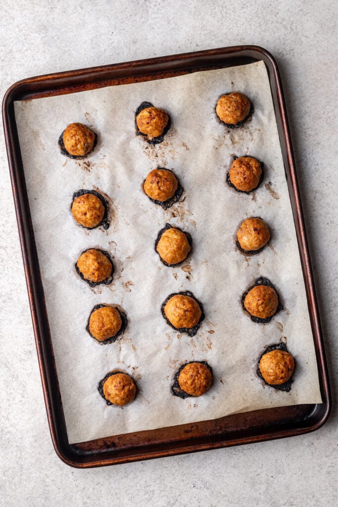 baked bbq chicken meatballs on a sheet pan with parchment paper