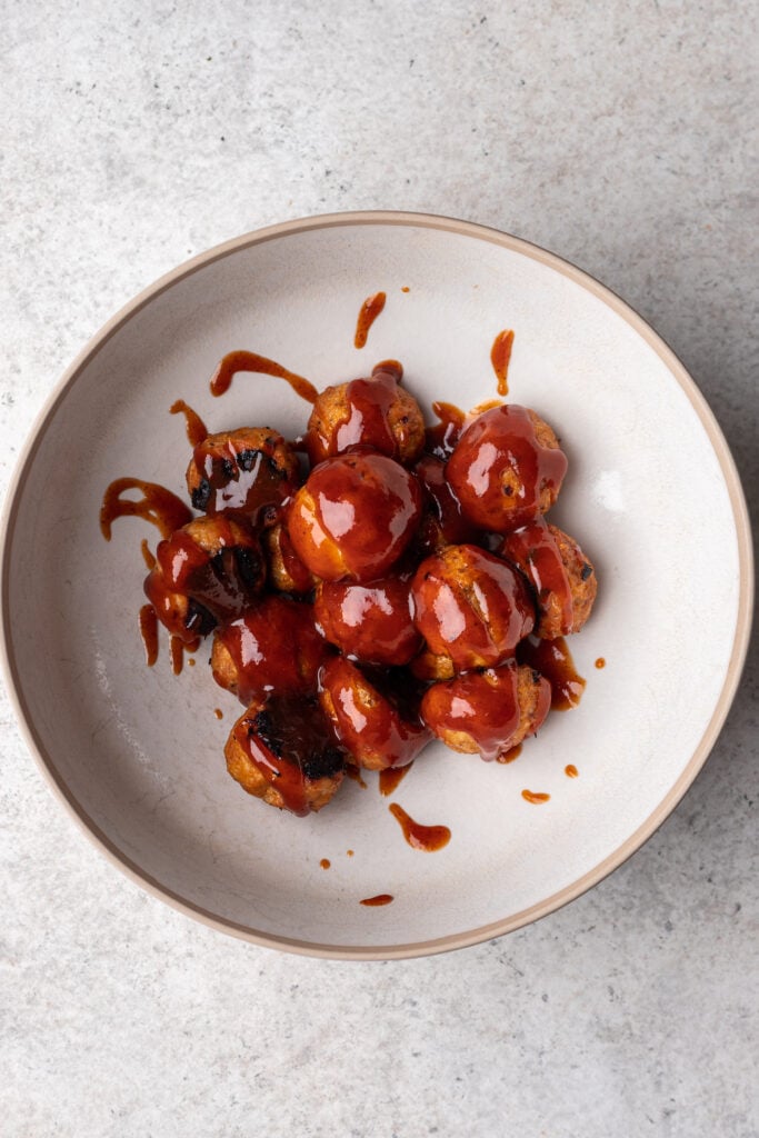 cooked chicken meatballs in a bowl with bbq sauce