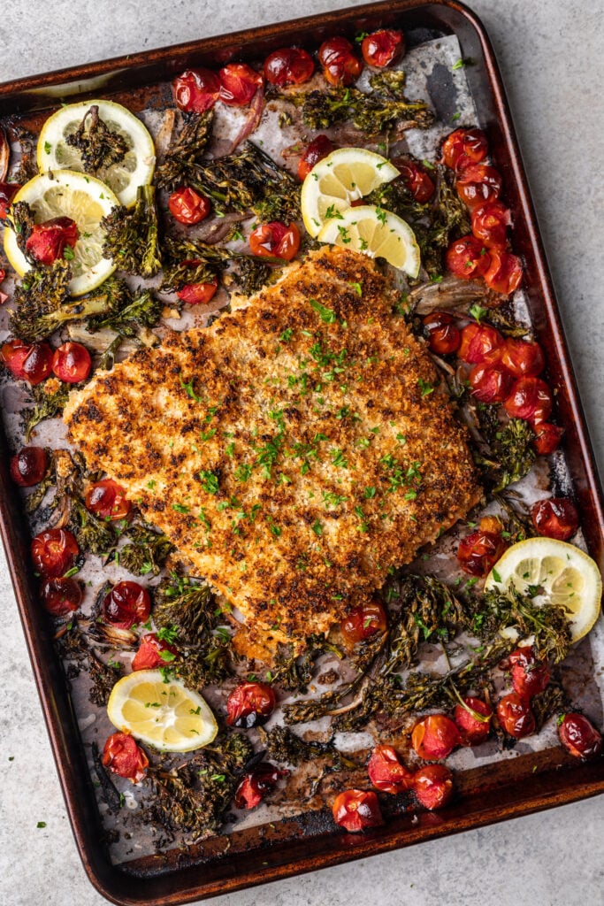 sheet pan with cooked broccolini, tomatoes and panko crusted salmon