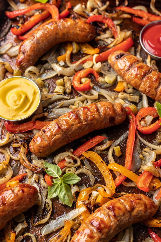 cooked sausage on a sheet pan with onions and peppers
