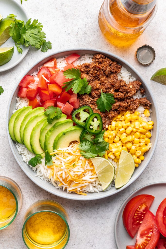 plate with taco meat, corn, avocado, tomatoes, cheese and jalepenos