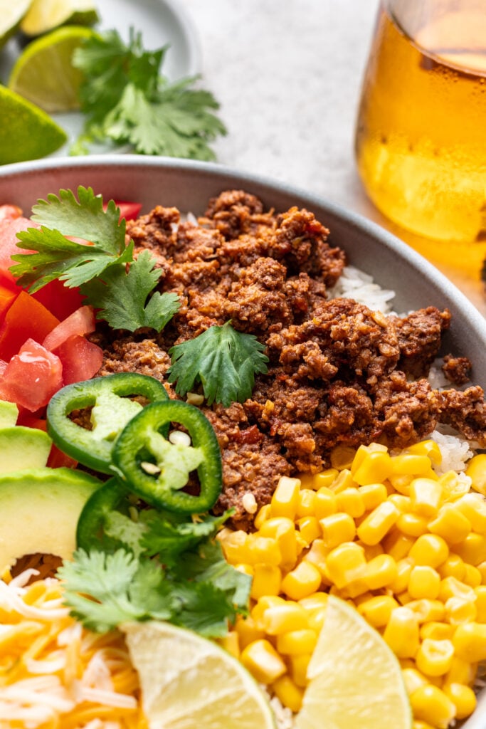 plate with taco meat, corn, avocado, tomatoes, cheese and jalepenos
