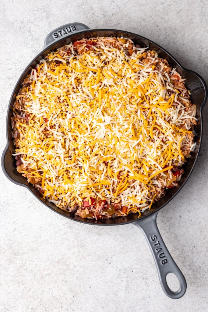 shredded cheese sprinkled on a skillet