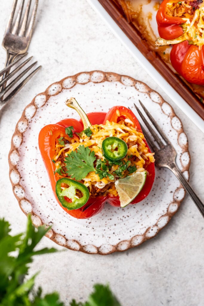a stuffed bell pepper with ground turkey and rice on a white plate with a fork