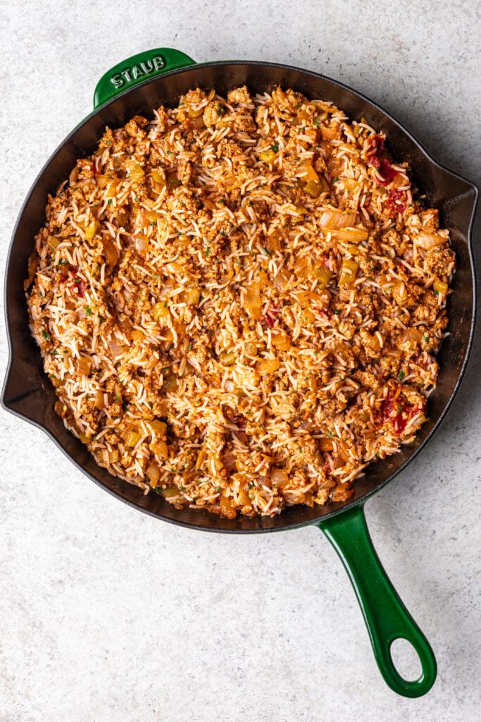 sauteed ground turkey in a pan with cooked rice