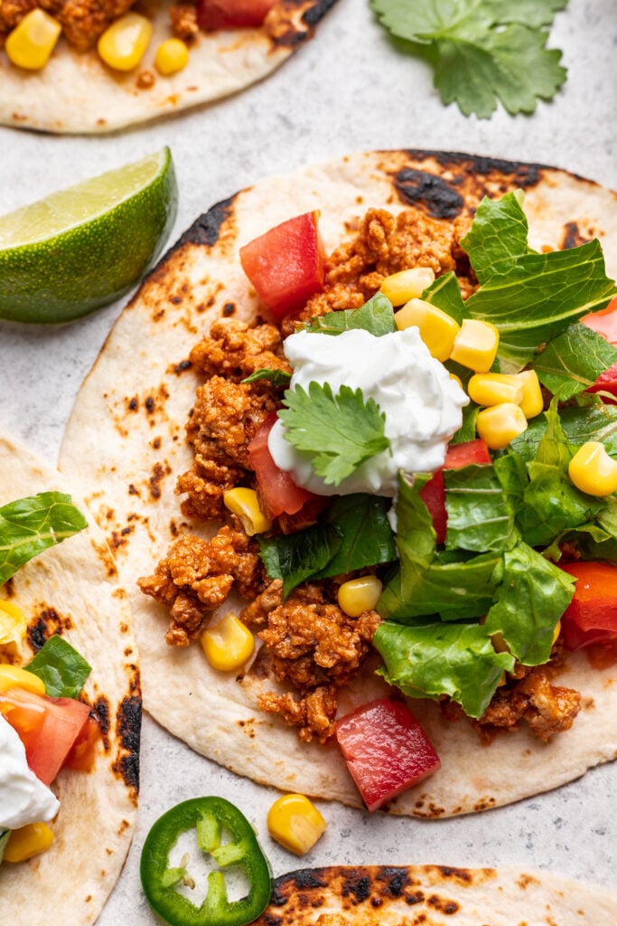 turkey taco with avocado, sour cream and a lime