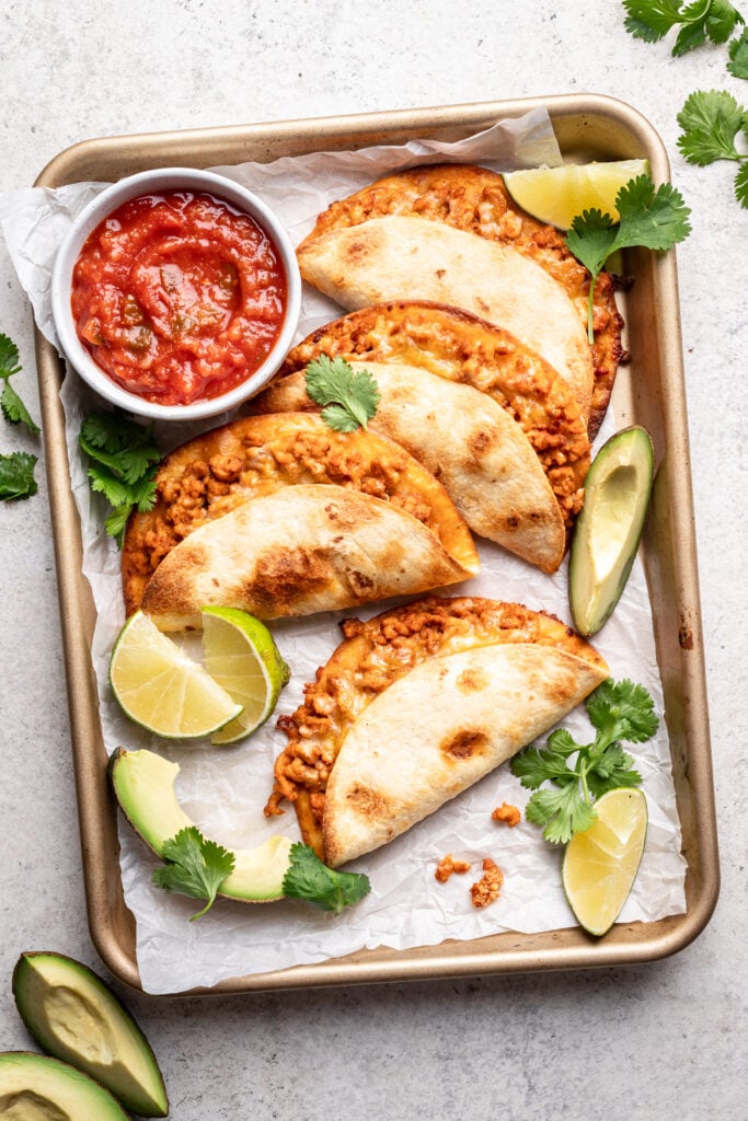 crispy chicken tacos with salsa on a sheet pan
