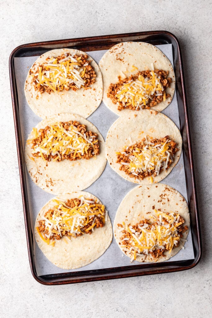 open tortillas filled with ground chicken and cheese